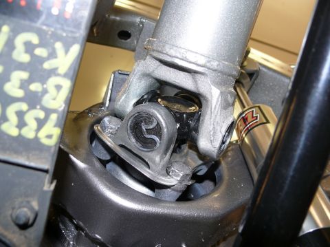 Driveshaft u-joint with visible part numbers on a yellow tag