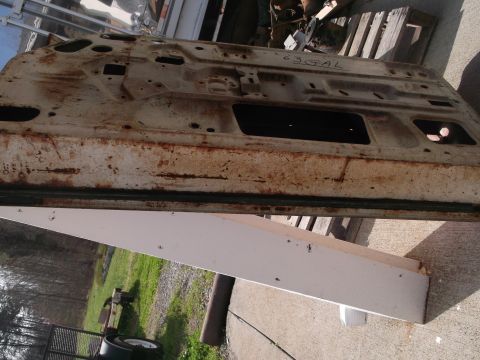 1971 Ford Ranchero - A weathered car door, possibly from a 1963 model, sits outdoors.
