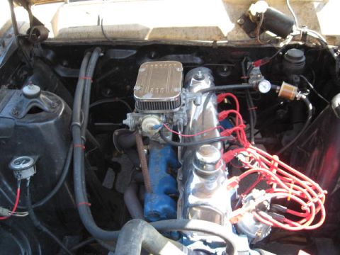1966 Ford Falcon - Close-up view of an engine bay a chrome air cleaner and red spark plug wires.