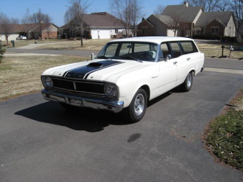 1966 Ford Falcon - A white 1966 Ford Falcon wagon with black racing stripes on the hood is parked on a suburban driveway.