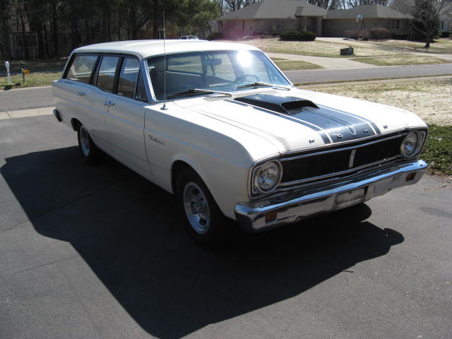 White 1966 Ford Falcon station wagon with black racing stripes on the hood, parked on a driveway