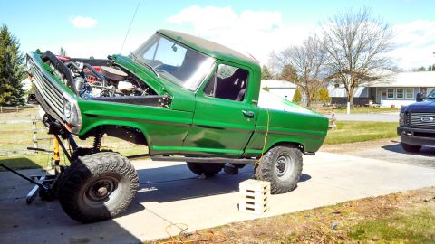 1967 Ford F-250 - A green 1967 Ford F-250 pickup truck is shown with its hood up, undergoing modifications.