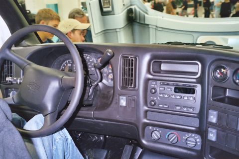 1992 Mercury Grand Marquis - The interior of a van is shown, focusing on the dashboard and steering wheel, with onlookers visible in the background.