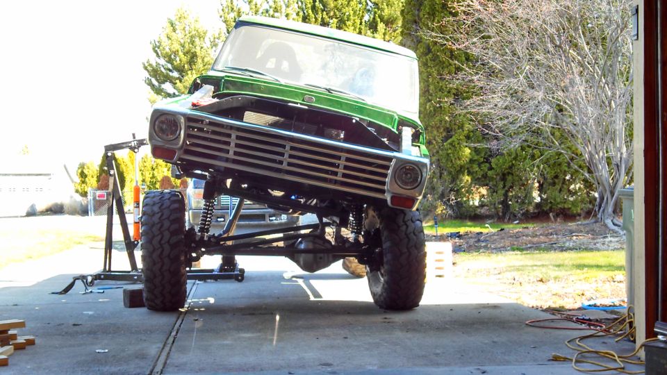 Green 1967 Ford F-250 with lifted suspension and custom grille