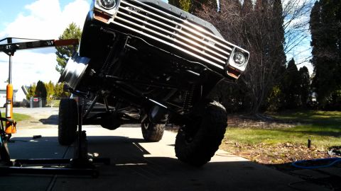 1967 Ford F-250 - A lifted Ford F-Series truck is shown from a low angle, with its front end elevated for maintenance.