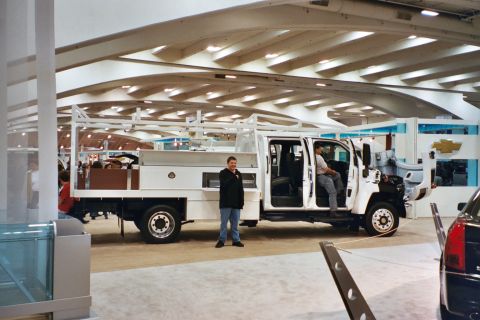 1992 Mercury Grand Marquis - A white utility truck is displayed indoors, possibly at an auto show.
