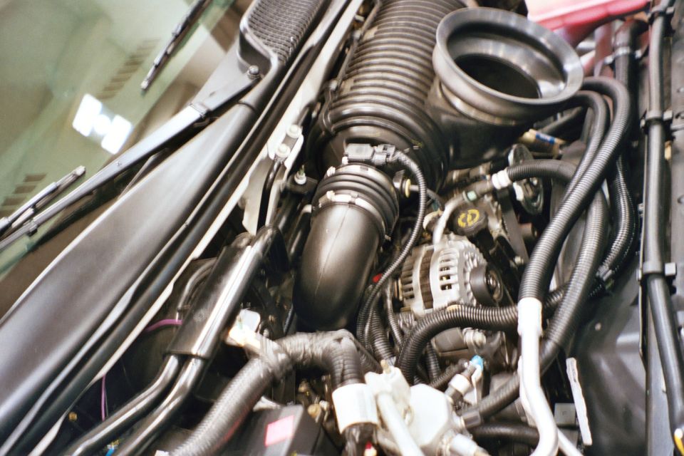 Engine bay with large air intake tube and alternator