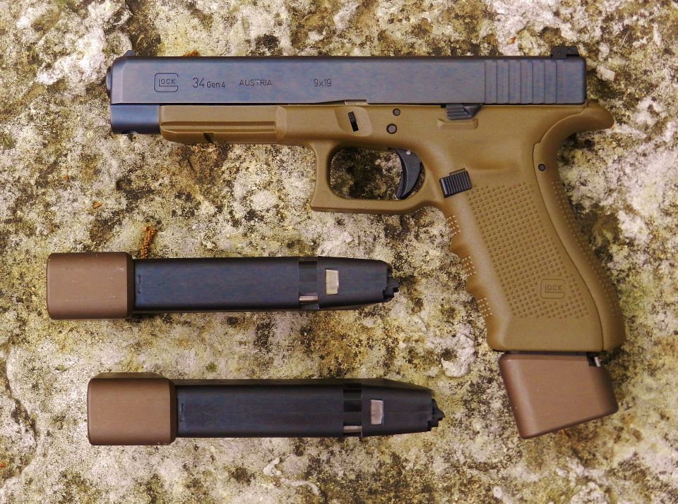 Glock 34 Gen 4 pistol with two extra magazines, one with an extended baseplate