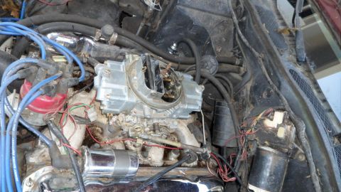1972 Ford Ranchero - Close-up view of a vehicle's engine bay, showing the carburetor and ignition system components.