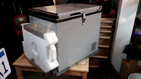 1985 Toyota 4Runner - Portable refrigerator unit with an auxiliary water jug mount, seen indoors.