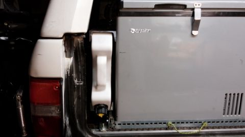 1985 Toyota 4Runner - Rear view of a 1985 Toyota 4Runner showing a portable refrigerator and water jug mounted inside.