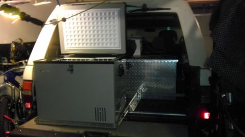 1985 Toyota 4Runner - The rear of a vehicle is shown with an open freezer and a metal toolbox installed.