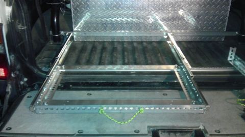 1985 Toyota 4Runner - A metal cargo slide-out tray is installed in the rear of a vehicle, with diamond plate metal above it.