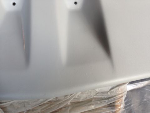 1992 Ford F-150 - A close-up view of a vehicle body panel that has been primed, showing two mounting holes at the top.