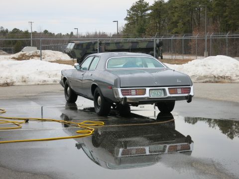 1991 Ford LTD Crown Victoria - Rear view of a 1977 Dodge Monaco sedan with a yellow hose nearby.
