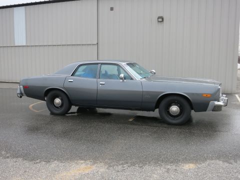 1991 Ford LTD Crown Victoria - This gray sedan is parked outside a building on a wet surface.