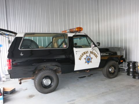1991 Ford LTD Crown Victoria - This highway patrol SUV is parked inside a garage with a corrugated metal wall.