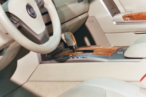 1992 Mercury Grand Marquis - The interior of a car features wood accents on the center console and gear shifter, with a portion of the steering wheel visible.