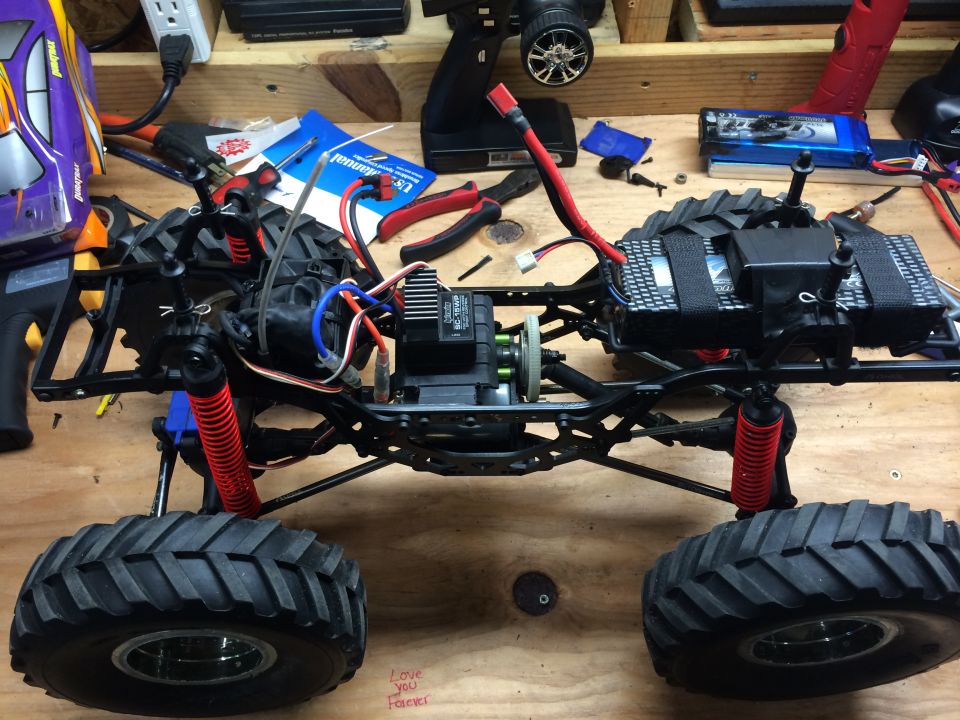 RC car chassis with large tires and red shocks