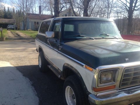 1979 Ford Bronco - This two-tone Ford Bronco is parked in a driveway with a house in the background.