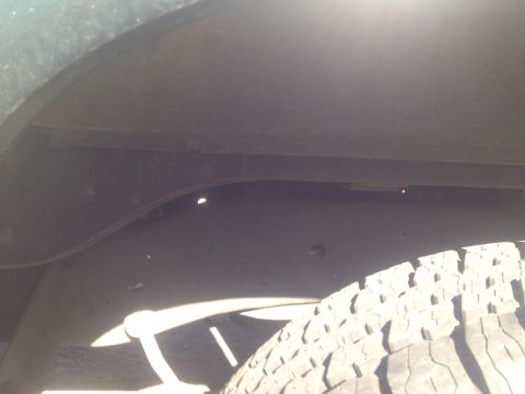 1979 Ford Bronco - A view of the wheel well and tire, showing the underside of the vehicle.