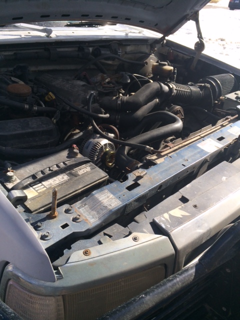 1996 Ford Bronco - The engine bay of a vehicle is viewed from above with the hood open.
