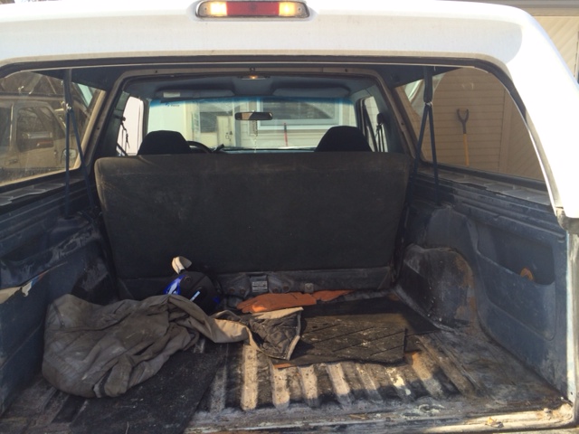 1996 Ford Bronco interior cargo area with seats folded down and items in the back