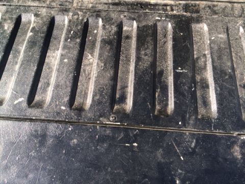 1996 Ford Bronco - The textured surface of a truck bed shows signs of wear and tear.