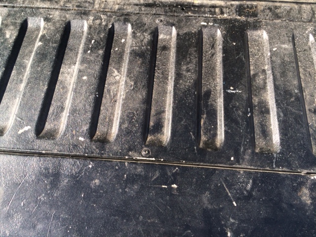 Close-up of a dirty truck bed with raised ridges