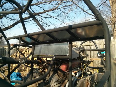 1986 Ford Bronco - Close-up view of a custom off-road vehicle's engine and roll cage structure.