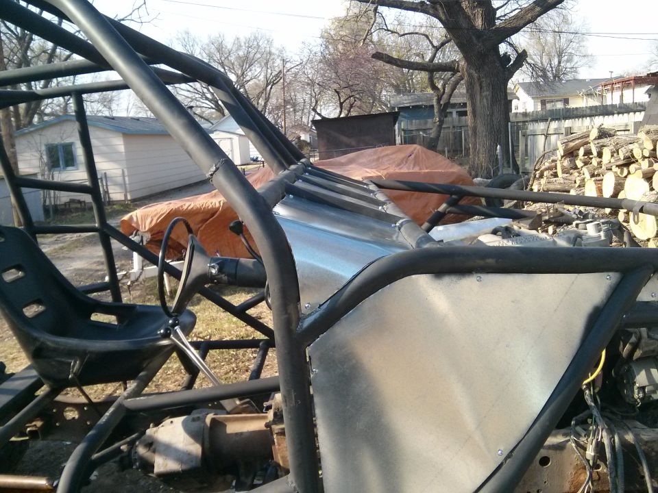 buggy chassis with roll cage, bucket seat, and steering wheel, outdoors