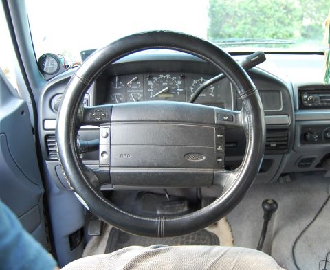 1994 Ford Bronco - The interior of a 1994 Ford Bronco, the steering wheel, dashboard, and gear shifter.