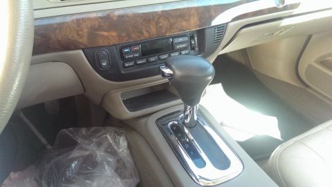 2000 Mercury Grand Marquis - The interior of a 2000 Mercury Grand Marquis features wood grain trim and a chrome-accented gear shifter.