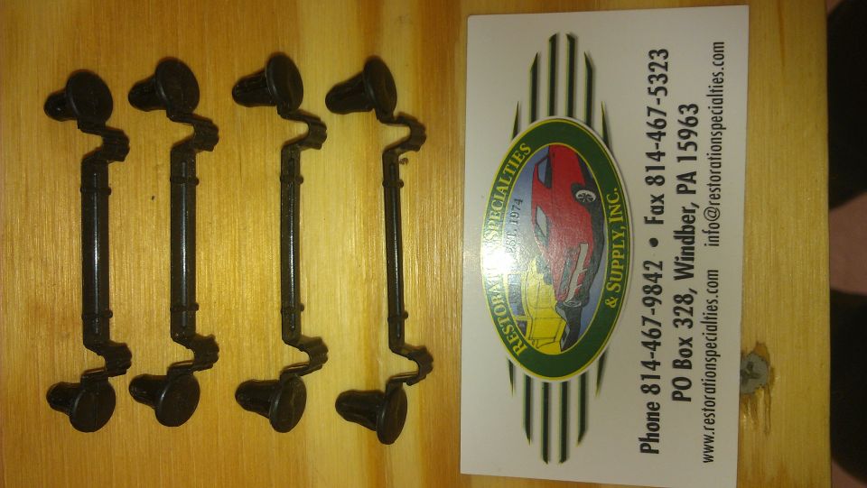 Four black metal brackets with rubber ends, next to a business card for Restoration Specialties & Supply