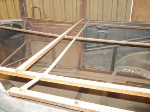 1929 Ford Sedan - Interior view of a 1929 Ford Sedan, showing its current state of restoration with visible rust and structural supports.