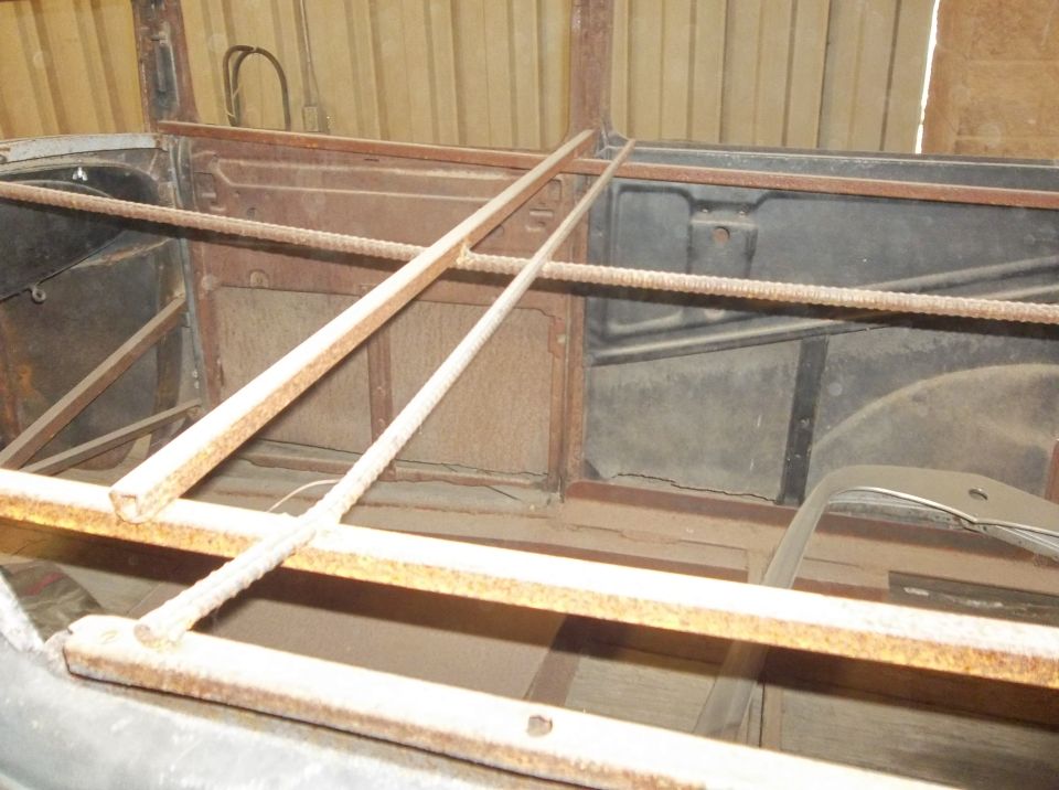 1929 Ford Sedan interior showing rusted metal panels and wooden support beams
