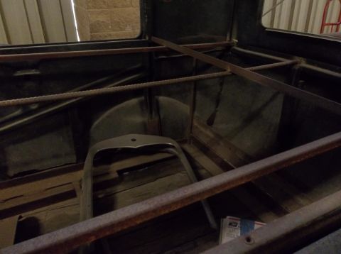 1929 Ford Sedan - The interior of a car shows its structural frame and a detached grille, suggesting it is undergoing restoration.