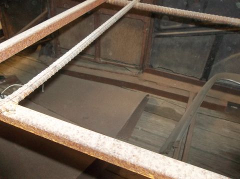 1929 Ford Sedan - The interior of a vintage vehicle shows significant rust and wear on its structural components and flooring.
