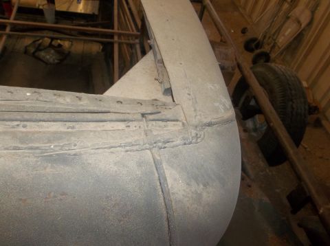 1929 Ford Sedan - A detailed view of a vehicle's rear fender and wheel well, highlighting the construction and a tire in the background.