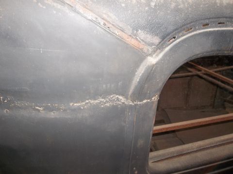 1929 Ford Sedan - Rust and dirt accumulate along a seam on a car's body panel.