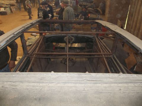 1929 Ford Sedan - The interior of a vehicle is being modified with a custom roll cage structure.