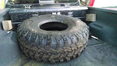 1985 Jeep CJ7 - Spare tire and toolbox stored in the bed of a pickup truck.