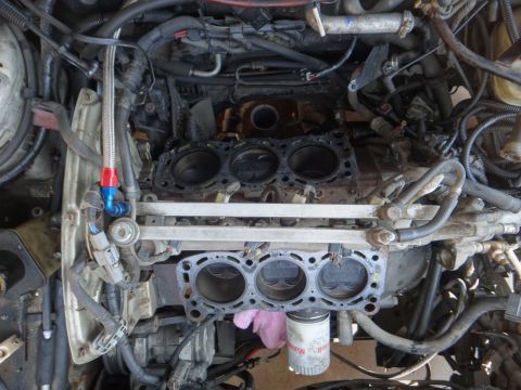 1993 Ford Taurus - Engine block with cylinder heads removed, revealing pistons and gasket remnants. An oil filter is visible at the bottom.