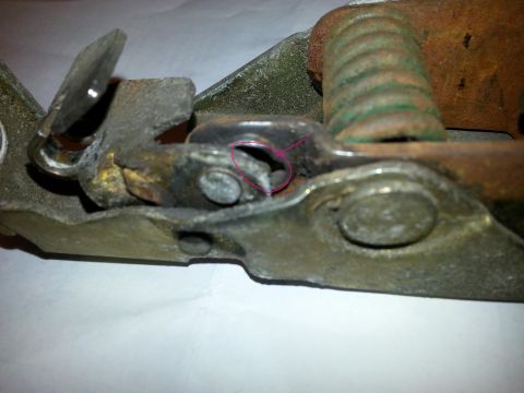 1995 Ford Bronco - Close-up of a vehicle's hood latch mechanism, with a pink circle indicating a damaged component.
