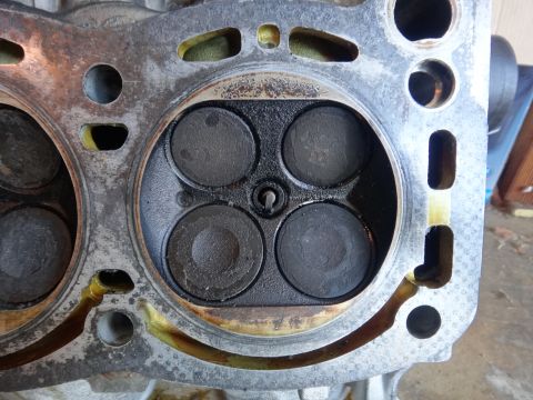 1993 Ford Taurus - Close-up view of an engine cylinder head, revealing four valves and signs of wear and carbon deposits.