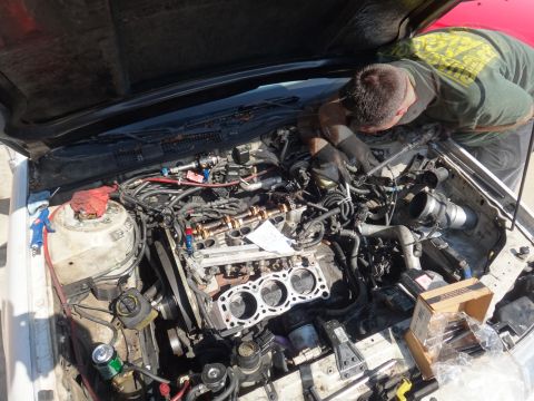 1993 Ford Taurus - Mechanic performs engine work, with cylinder heads removed and pistons exposed.