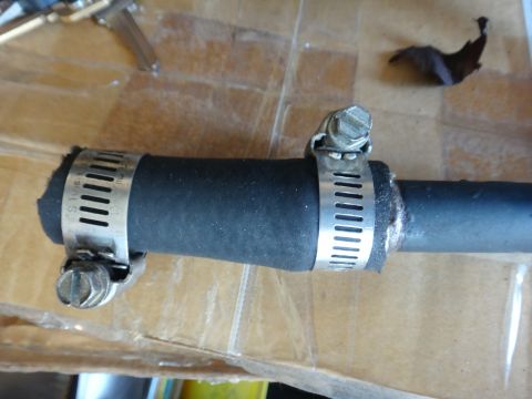 1993 Ford Taurus - A rubber hose is held together by two metal hose clamps.