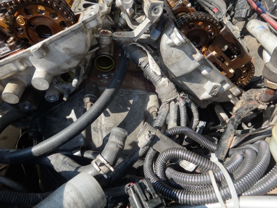 Disassembled engine components with timing chains and hoses