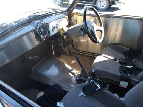 1964 Mercury Monterey - The interior of a custom vehicle features aftermarket gauges and racing seats, with a metallic finish on the dashboard and door panels.