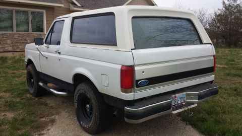 1985 Yugo GVX - Rear view of a white Ford Bronco, likely from the late 1980s, parked outdoors.